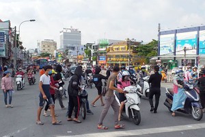 當交通信號轉為紅燈，車輛停止前進時，上十人擁出街道上，擠過每輛車，以派發有關房地產、信用貸款、出售貨品等內容的廣告傳單。