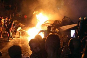 人們正在撲救爆炸引發的大火。（圖源：路透社）