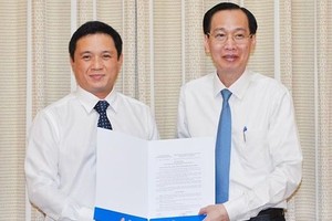 新任市計劃與投資廳副廳長阮忠英（左）從市人委會常務副主席黎清廉手中接過人事委任《決定》。（圖源：越勇）