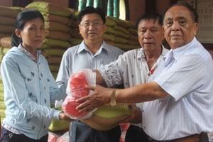 鄭氏宗祠榮譽理事長鄭紹明（右一）向宗親派發盂蘭節禮物。