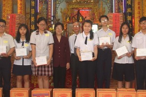 市各少數民族文學藝術協會主席劉金華及該 會館常務副理事長陳健智向瓊裔子弟頒獎。