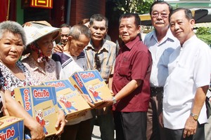 浸石天后宮理事長張敬和(右三)與各副理事長 向貧困同胞派發禮物。