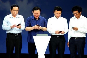 政府副總理王廷惠（左二）同越南祖國陣線中央委員會主席陳清敏（左一）在響應“2019年全國攜手為貧民”行動儀式上發送捐助貧困者短訊。（圖源：真論）