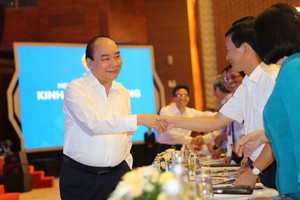 政府總理阮春福（左）同與會代表親切握手，互致問候。（圖源：PV）