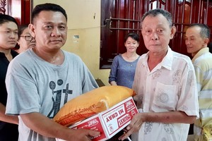 沙瀝市明月居士林林長江忠盛(右)向窮人發禮品。