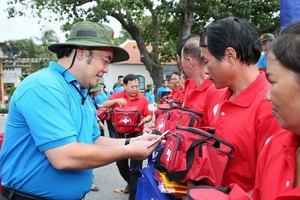 市勞動聯團常務委員副主席胡春霖（左）向崑崙島漁民贈送國旗和禮物。（圖源：勞動者報）