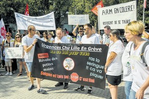 圖為里爾急診醫生和醫護人員日前在里爾市政府前抗議。（圖源：AFP）