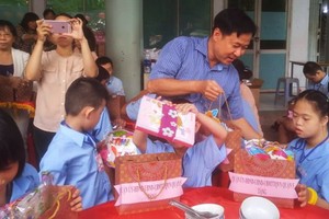 郡祖國陣線委員會主席黎晉才向殘疾學生派發禮物。