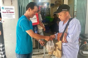 貧困者前往妙常飯店領取飯菜。