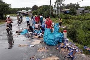 當地民眾幫忙司機，把啤酒拾起放在路邊，然後把完整的一罐罐啤酒放進麻袋裡。（圖源：黎龍）