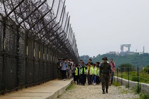 遊客正在體驗非軍事區徒步遊，步道周圍鐵絲網環繞。（圖源：互聯網）
