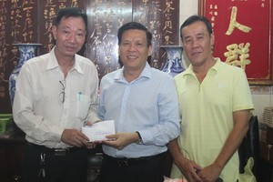 本報主編阮玉英（右二）接受周華邦住持贊助善款。