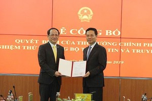 新任新聞與傳播部副部長范英俊（左）從新聞與傳播部部長阮孟雄手中接過人事委任《決定》。（圖源：英黎）