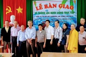 楊怡生（左四），倪耀茂（左六）和李成南 （左七）等澳洲越僑探訪團在移交小學地下水過 濾淨化器儀式上合攝。 