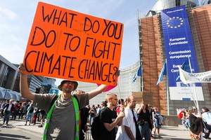 在比利時布魯塞爾民眾手持標語參加氣候變化遊行。（圖源：新華社）