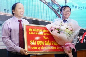 《海防報》總編輯向《西貢解放報》總編輯阮晉豐(右)轉交下一次座談會舉辦權。（圖源：杜忠）