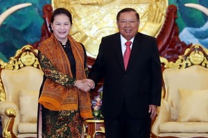 國會主席阮氏金銀與老撾總書記、國家主席本揚握手。（圖源：越通社）