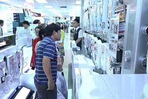 消費者在電器超市裡選購空氣淨化器。（示意圖源：田升）