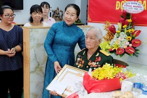 市委副書記武氏蓉向劉文攸同志頒授75年黨齡紀念章。（圖源：市黨部新聞網）
