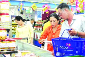 消費者在超市選購價格平抑商品。