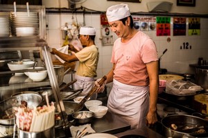 華人麵家的廚師正在煮麵服務食客。