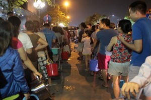 河內市民眾夜間手提著水桶排隊打水。（圖源：VTC）
