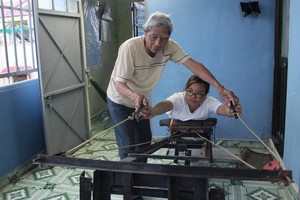 陳煌明研究製造出讓孩子們鍛煉手力的一台機。圖片中是陳煌明與韋氏姮。