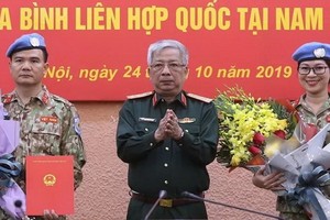 國防部副部長阮志詠上將向參加聯合國維和部隊活動的兩名軍官頒發國家主席的《決定》。（圖源：嘉政）