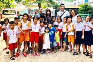 台商代表團與該中心主任黃小香和孤兒合照留念。