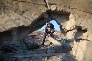 11月2日，在加沙地帶南部城市汗尤尼斯，一名巴勒斯坦人查看以軍空襲造成的廢墟。（圖源：新華社）