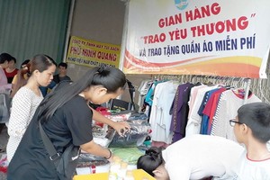 第八郡第十六坊婦女會到各個工業區開設“分享愛心”攤位，給工人 贈送衣物。