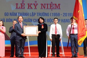 國家副主席鄧氏玉盛（中）向梁文悴高中專校頒授二等獨立勳章。（圖源：阮長）