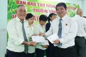 董事長陳金泉（右）頒發獎金給老師、員工。