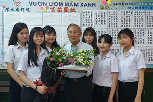 啟秀初中生向 55 年黨齡黨員、校長王沛川贈送鮮花。