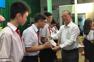 穗城會館理事長盧耀南向郡級優秀生頒獎。