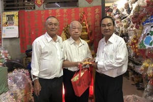 華人商販楊光澤（中）獲福中校友會贈送敬老禮物。