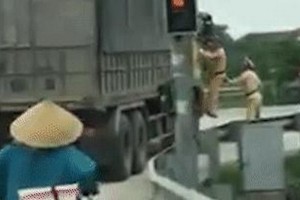 卡車司機不執行號令，故交警跳上抓住車門，堅決要求司機停車。（圖源：視頻截圖）