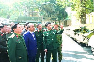 政府總理阮春福（前左二）參觀國防部的陳列。（圖源：光孝）