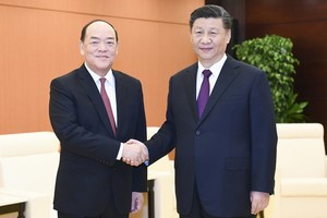 中國國家主席習近平（右）會見賀一誠。（圖源：新華社）