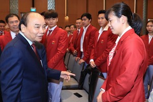 政府總理阮春福（前左）與運動員交流。（圖源：越通社）