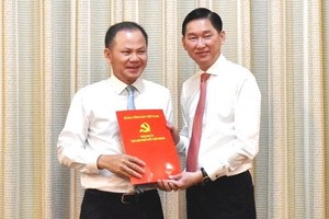 市海關局局長丁玉勝（左）從市人委會副主席陳永線手中接過人事委任《決定》。（圖源：芳陲）