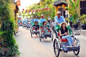 國際遊客坐三輪車參觀會安古埠。