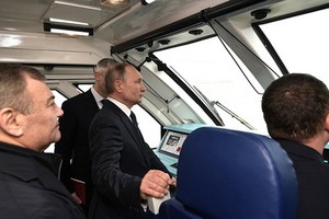 俄羅斯總統普京（中）乘坐列車穿過克里米亞大橋鐵路橋。（圖源：互聯網）