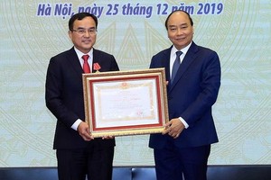 阮春福總理向EVN董事長楊光成頒授一等勞動勳章。（圖源：越通社）