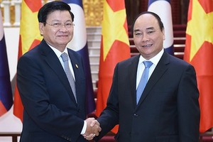 老撾人民民主共和國政府總理通倫‧西蘇里（左）與政府總理阮春福。（圖源：VGP）