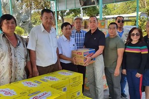 熱心人士劉根全(中右)代表眾友把食用品轉贈給該中心主任阮文石。