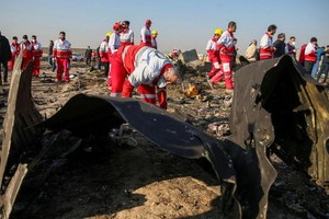 紅十字會成員在墜機現場。（圖源：路透社）