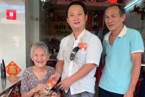 崇正興寧福利組理事長鄒國榮（中）向高齡鄉親贈送新年禮物。