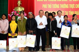 政府常務副總理張和平（中）向廣治省少數民族、環境貧困民戶贈送2020庚子年春節禮物。（圖源：黎山）