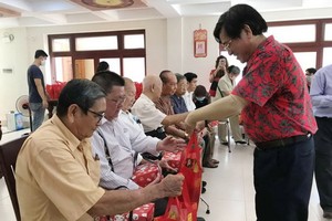 何氏宗祠理事長何冠忠向高齡宗親及麥氏顧問派發紅包和禮物。